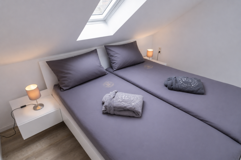 Modernes Doppelbett in gemütlichem Schlafzimmer im SEASIDE Wangerooge – komfortable Unterkunft für Fasten an der Nordsee.